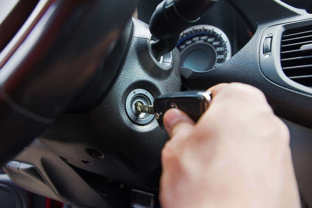 Man Inserting A Key To The Car Ignition Switch