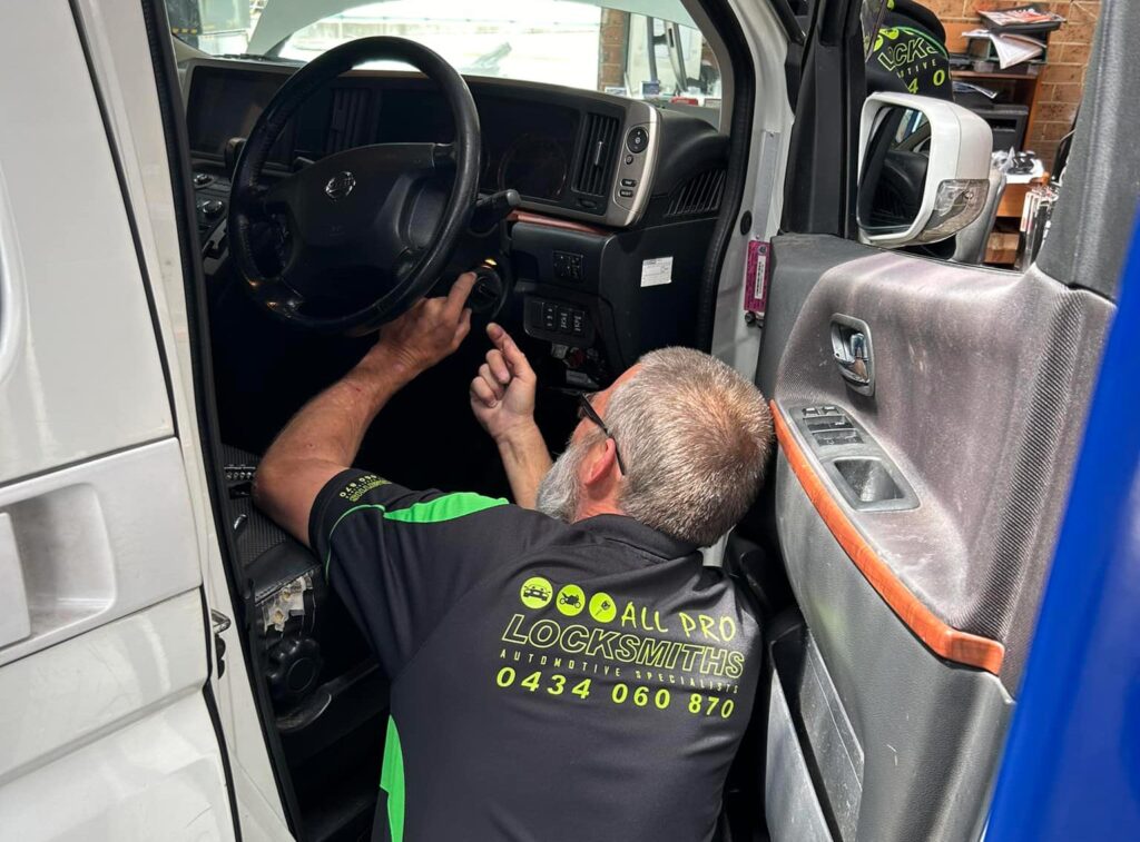 Auto Locksmith Inspecting The Ignition Of A Vehicle
